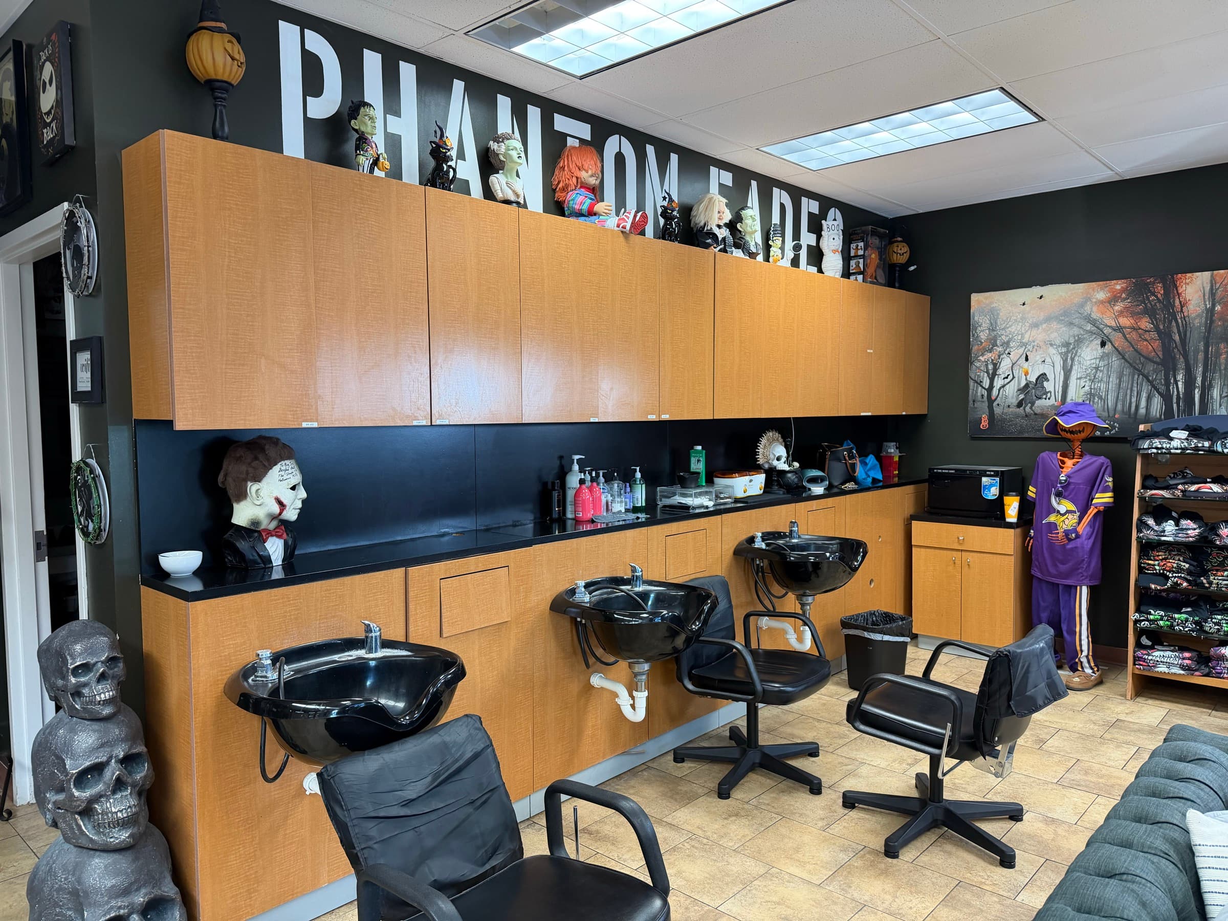 Phantom Fades back wall with shop-name lettering, Chucky figurine, decorative skulls, and a Vikings jersey