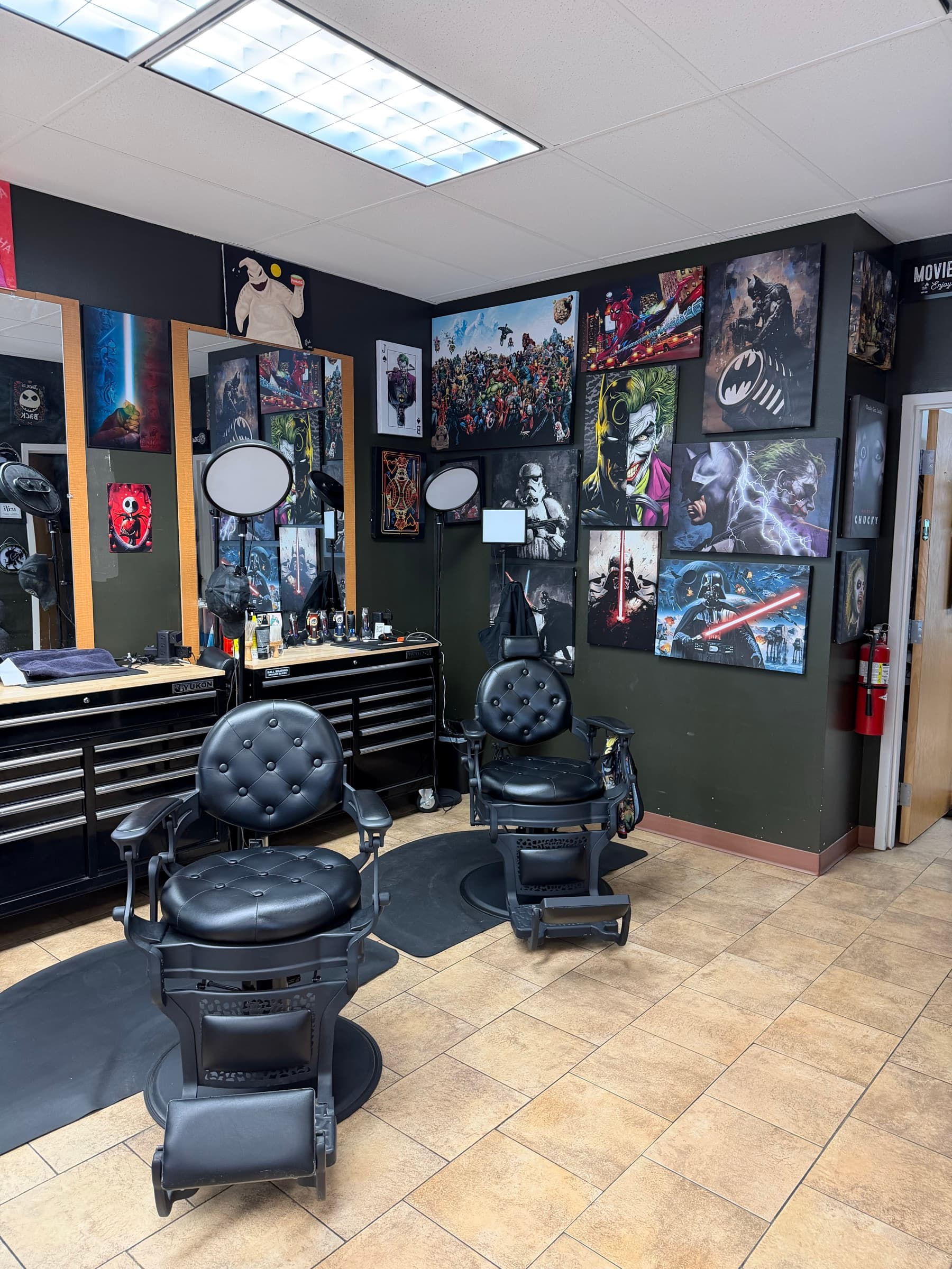 Phantom Fades cutting station with black tufted chairs and a wall of Marvel, Star Wars, and horror movie posters