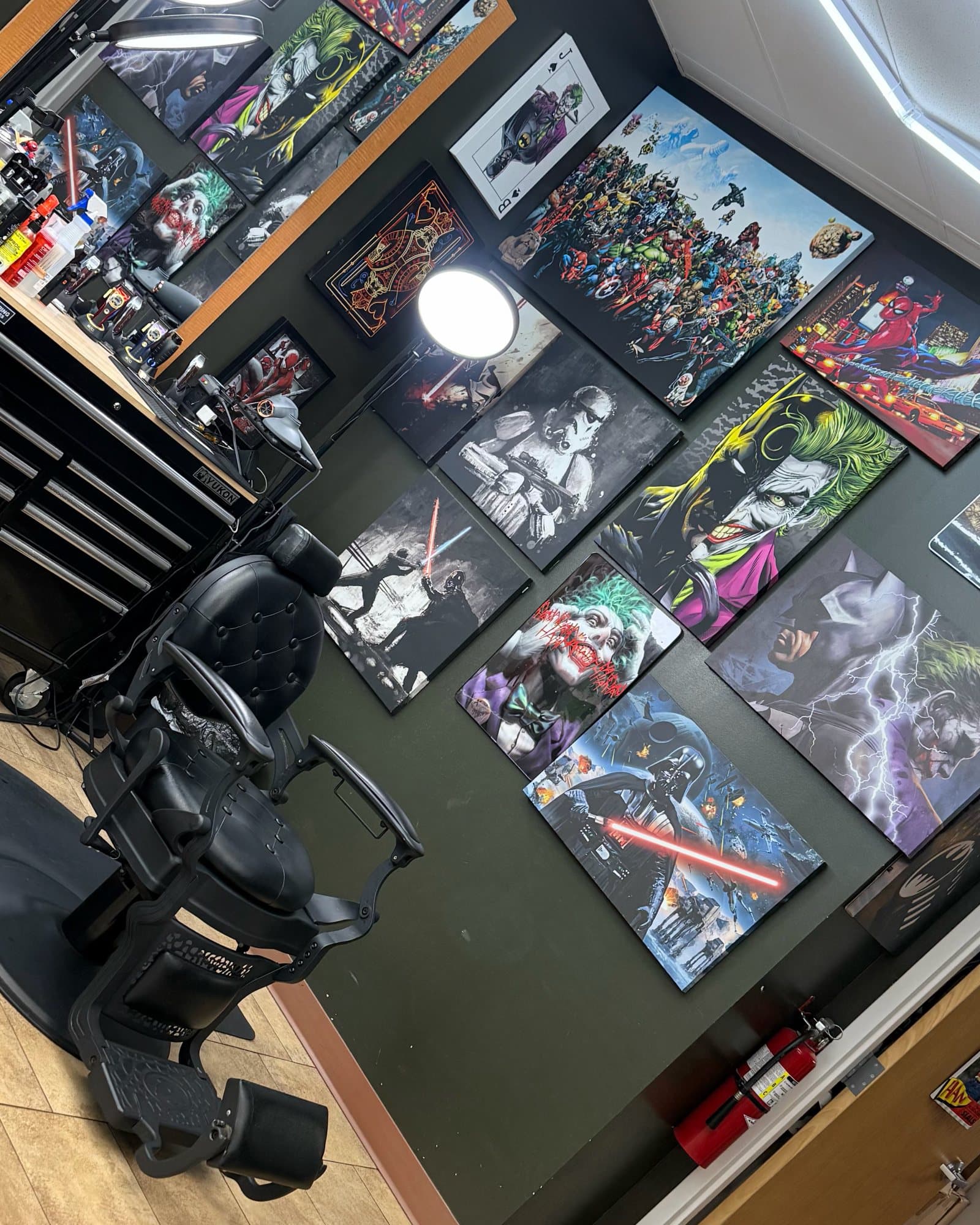 Black tufted barber chair in front of a wall of Joker, Batman, Star Wars, and Marvel canvases at Phantom Fades
